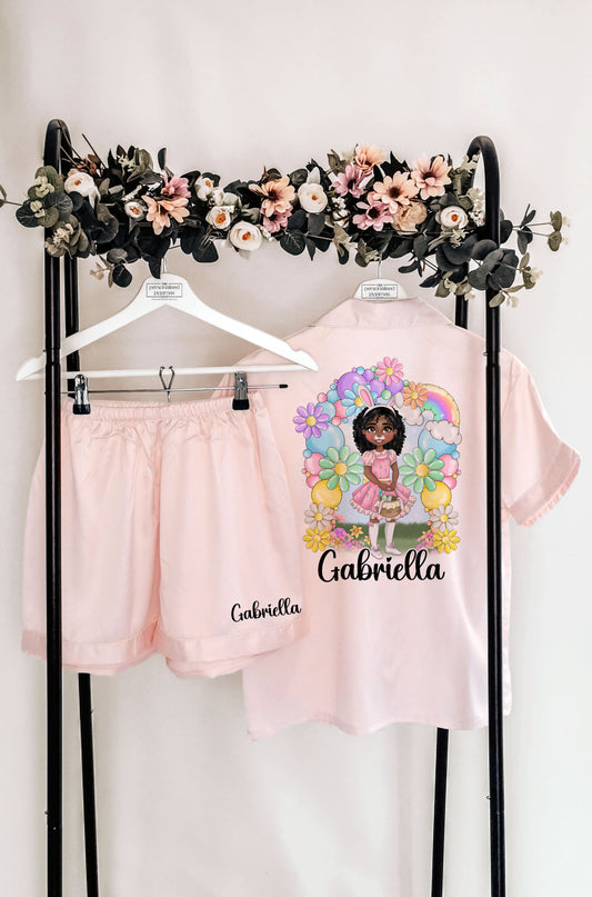 A beautiful personalised Easter pyjama set and robe featuring a custom dollie design, surrounded by pastel flowers and a bunny theme. Includes custom name, hair colour, eye colour, and skin tone for a truly unique touch.