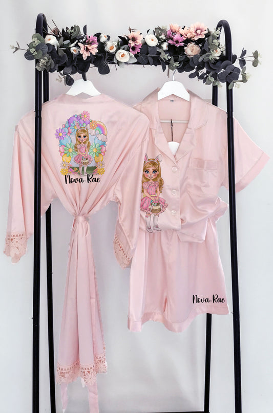 A beautiful personalised Easter pyjama set and robe featuring a custom dollie design, surrounded by pastel flowers and a bunny theme. Includes custom name, hair colour, eye colour, and skin tone for a truly unique touch.
