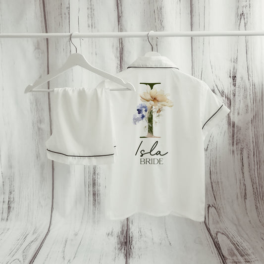 A beautifully designed personalised wedding robe and pyjama set featuring a delicate floral initial design. Perfect for brides, bridesmaids, and the bridal party, available in various sizes for a timeless and sophisticated look.