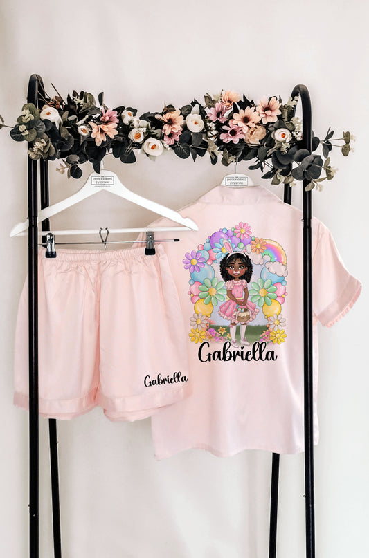 A beautiful personalised Easter pyjama set and robe featuring a custom dollie design, surrounded by pastel flowers and a bunny theme. Includes custom name, hair colour, eye colour, and skin tone for a truly unique touch.

